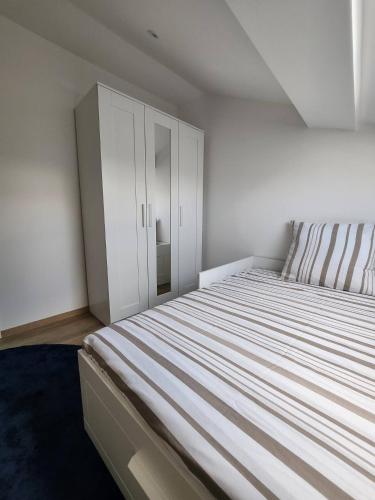 a bedroom with a bed and a white cabinet at Suite et duplex avec terrasse en hyper centre in Charleville-Mézières