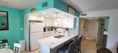 a kitchen with a white counter and blue walls at Fiesta Sol #110 home in South Padre Island