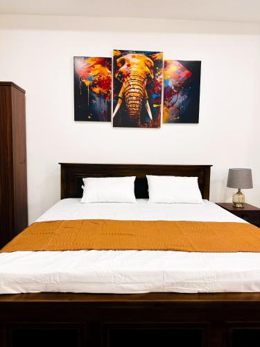 a bedroom with three paintings of an elephant on the wall at Happy Haven Homestay in Anuradhapura