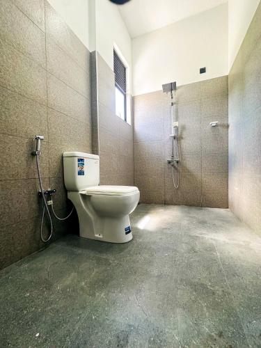a bathroom with a toilet and a shower at Happy Haven Homestay in Anuradhapura