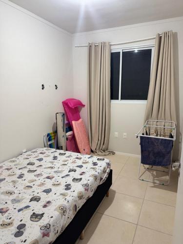a bedroom with a bed and a cart next to a window at Oceanfront apartment with beautiful view in Palhoça