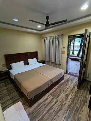 a bedroom with a large bed with a ceiling fan at Aayush Resort in Kālundri
