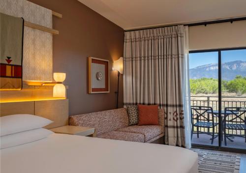 a hotel room with a bed and a balcony at Hyatt Regency Tamaya South Santa Fe in Santa Ana Pueblo