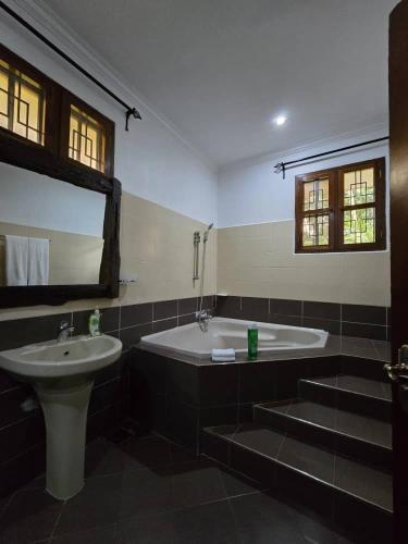 a bathroom with a sink and a bath tub and a sink at Sprunger Retreat - tulia homes in Moshi