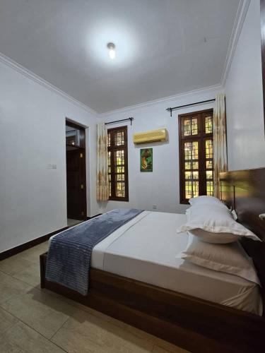 a bedroom with a large bed with white sheets and pillows at Sprunger Retreat - tulia homes in Moshi