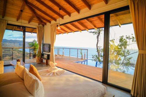 a living room with a bed and a balcony at Vista del Alma Boutique - Adult Only in Santa Teresa Beach