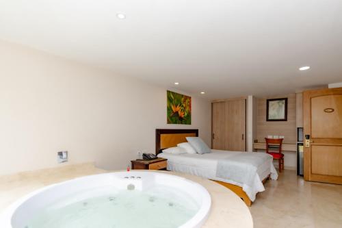 a bedroom with a large bath tub and a bed at Hotel San Pedro del Fuerte in Medellín