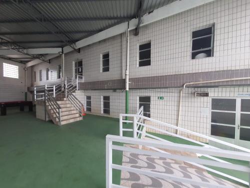 - un bâtiment avec des escaliers et une clôture devant dans l'établissement APTO 337 Malibu Praia Grande SP, à Praia Grande