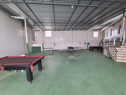Cette grande chambre comprend une table de ping-pong. dans l'établissement APTO 337 Malibu Praia Grande SP, à Praia Grande