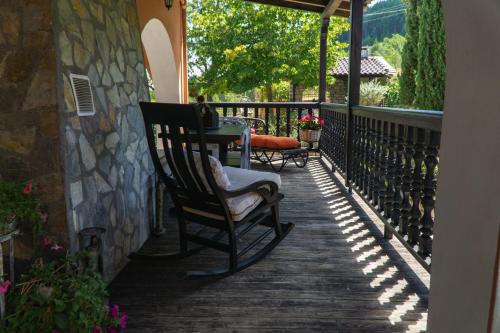a porch with a rocking chair and a table at Villa Tethys Mountain Resort in Zákas