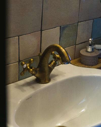 a brass faucet on a sink in a bathroom at Villa Tethys Mountain Resort in Zákas