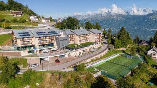an aerial view of a resort with a tennis court at Hotel Monte Bondone in Vaneze