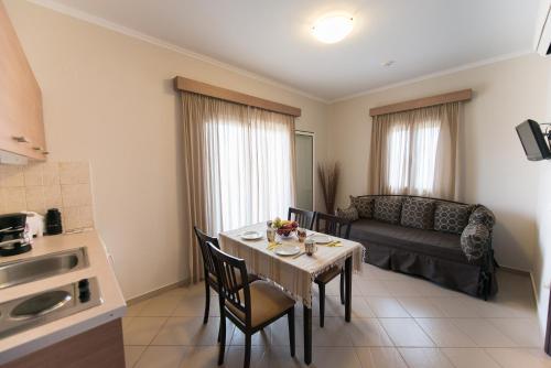 a living room with a table with chairs and a couch at Christina Studios in Lygia