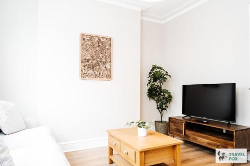 a living room with a tv and a coffee table at Alice's Central Stay: Parking + Close to the Motor Point Arena in Nottingham