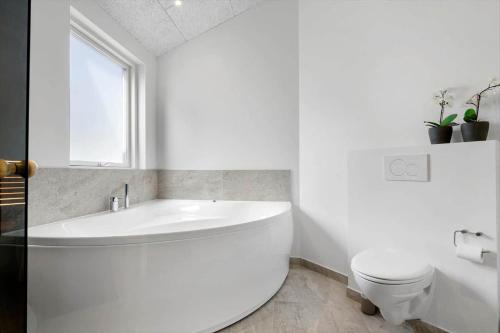 a white bathroom with a tub and a toilet at SJ256-Haderslev-Sonderballe-Strand-83-A in Haderslev