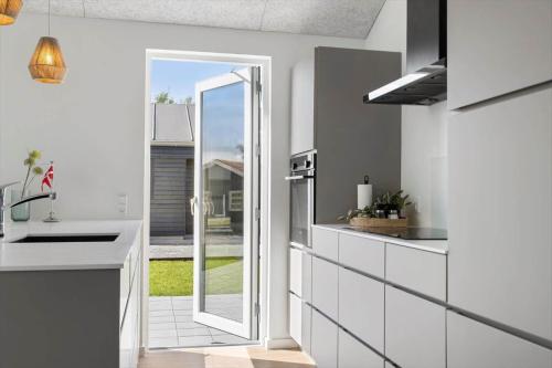 a kitchen with a door leading to a patio at SJ256-Haderslev-Sonderballe-Strand-83-A in Haderslev