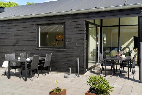 a patio with a table and chairs in front of a building at SJ256-Haderslev-Sonderballe-Strand-83-A in Haderslev