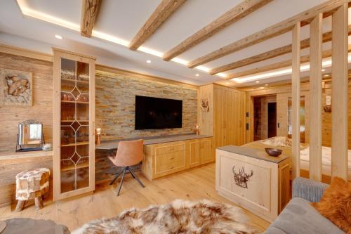 a bedroom with a bed and a tv on a brick wall at Seefeld ALPIN - Rustikales TIROLER CHALET Studio Apartment in Seefeld in Tirol