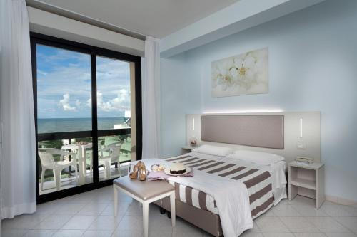 a bedroom with a bed and a view of the ocean at Hotel Carlton in Riccione