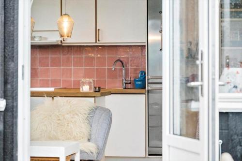 a kitchen with white cabinets and a chair and a sink at SJ204-Borkop-Pytvej-1 in Børkop