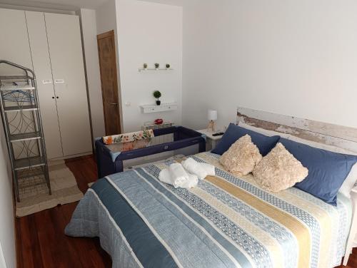 a bedroom with a blue bed with towels on it at Cruz de Baixar in Fisterra