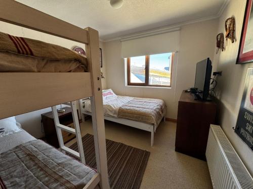 a dorm room with two bunk beds and a television at HOM I En el Centro SKI Valle Nevado 3D2B SKI IN y OUT in Lo Barnechea