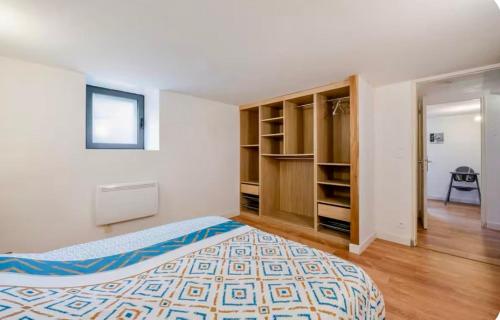 a bedroom with a bed and a book shelf at Côté Jardin, Entre lac et montagne in Publier