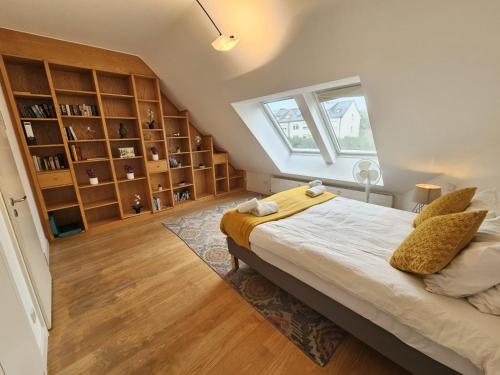 Un dormitorio con una cama grande y una ventana. en Luxurious 3BR Penthouse w terrace&parking, en Luxemburgo
