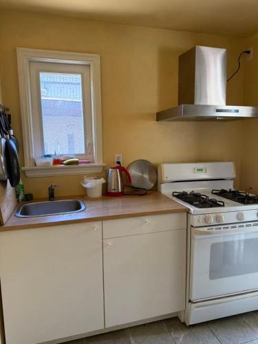 a kitchen with a white stove and a sink at Tom home in Toronto