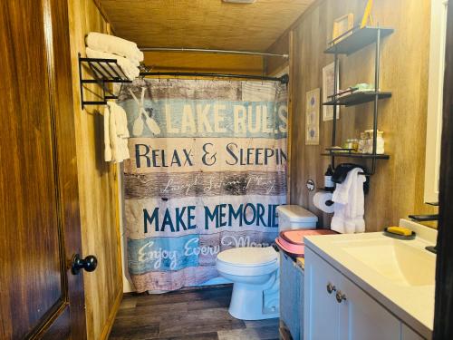 a bathroom with a toilet and a shower curtain at Coco Chateau ViP Cabin Lake Guntersville Pet Friendly Fully Fenced Boat Parking Private in Guntersville