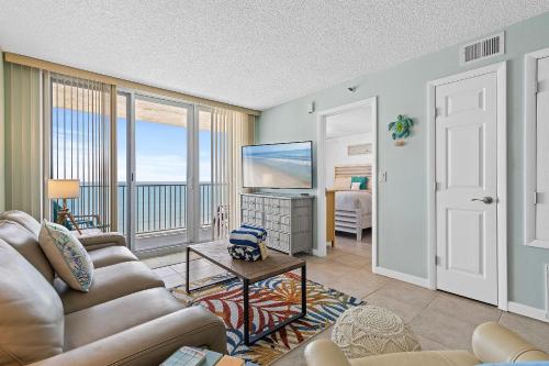a living room with a couch and a flat screen tv at Oceanfront Condo at Oceania Beach Club - Pool, Balcony, Sleeps 6, Walk to Flagler Ave! in Chicken Island