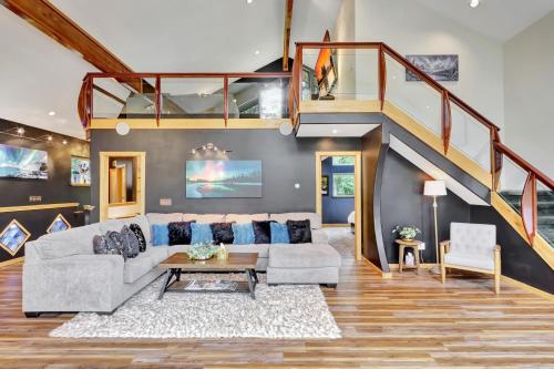 a living room with a couch and a staircase at Timberline Tranquility in Girdwood