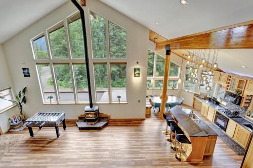 a large living room with large windows and wooden floors at Timberline Tranquility in Girdwood