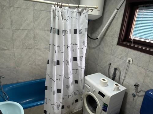 a bathroom with a shower curtain next to a toilet at 2 rooms in Struga