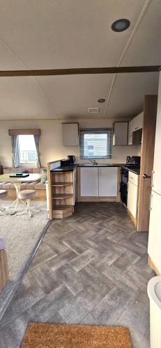 an empty room with a kitchen and a table at Abi Summer Breeze - West Sands in Selsey