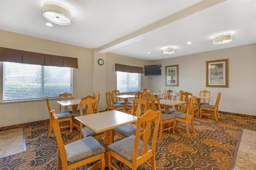 Un comedor con mesas y sillas y un televisor. en Best Western Northwest Inn, en Dallas