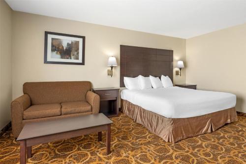a hotel room with a large bed and a chair at Best Western Northwest Inn in Dallas