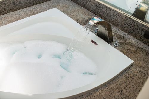 a bathroom sink with water pouring into it at Motel Platinum in Londrina