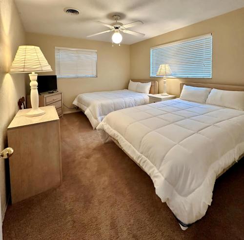 Un dormitorio con dos camas y un ventilador de techo. en Speed & Sand Pool Table, Parking & Minutes to Beach Or Speedway, en South Daytona