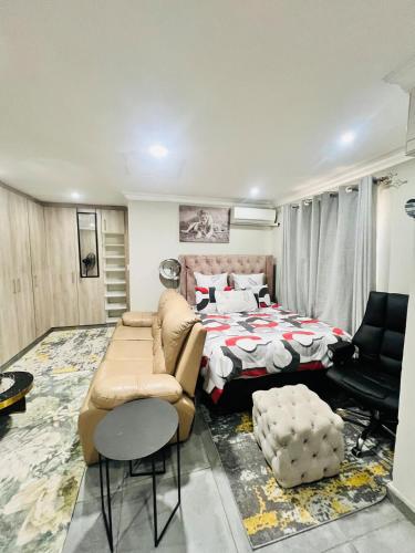 a bedroom with a bed and a couch and a chair at Modern Comfort with Easy Access Everywhere in Vanderbijlpark