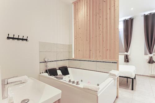 a white bathroom with a tub and a sink at LES BULLES DE MONA - Lola - Spa - Clim in Lyon
