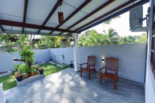 two chairs under a pergola on a patio at Sharasvee Nature Villa in Talalla