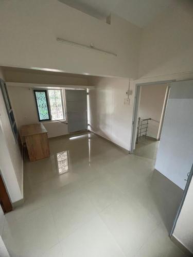 a large empty room with a table and a window at Souparnika in Varkala