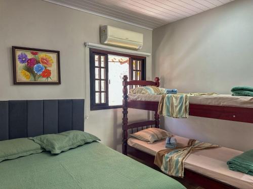 a room with two bunk beds and a window at Bella Mar Suítes in Angra dos Reis