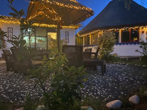 a patio with benches and a building with lights at Casa Soarelui in Murighiol