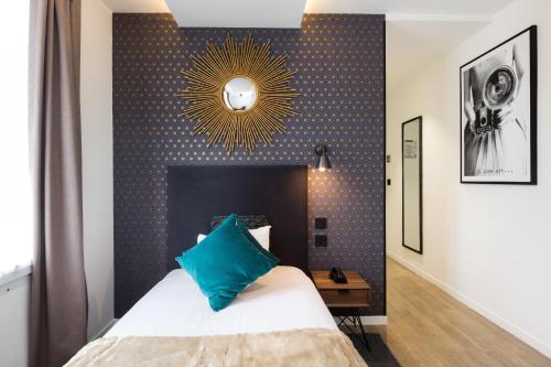 a bedroom with a bed with a blue wall at Hotel OHM by Happyculture in Paris