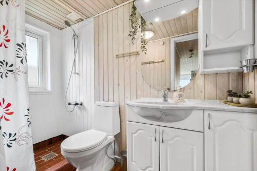 un bagno con un water, un lavandino e uno specchio di SJ269-Hejls-Ved-Kysten-1 a Hejls