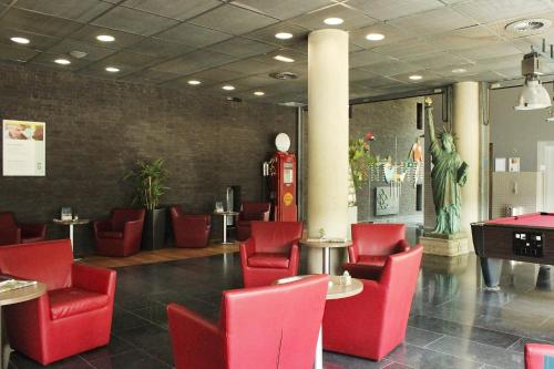 a restaurant with red chairs and tables in a room at Garner Hotel Maastricht by IHG in Maastricht