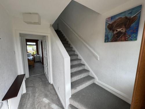 a staircase in a house with a painting on the wall at Sea Road Retreat - Great for contractors in Methil