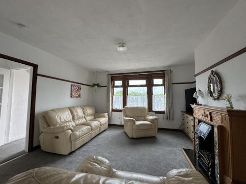 a living room with a couch and two chairs at Sea Road Retreat - Great for contractors in Methil